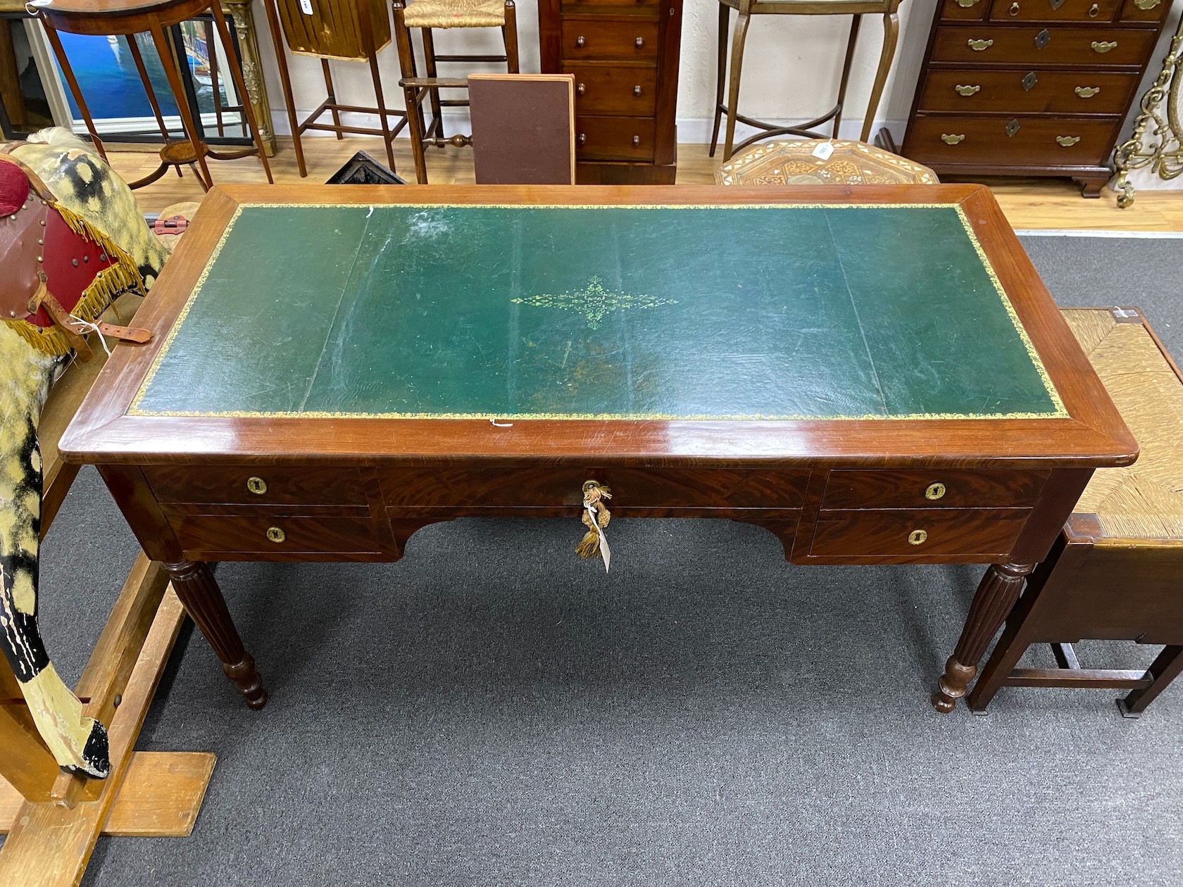 An early 20th century French mahogany kneehole writing table on fluted legs width 144cm, depth 71cm, height 76cm.